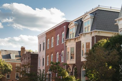 a row of brick buildings with trees in front of them