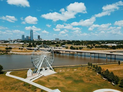 white ferris wheel near body of water under blue sky during daytime