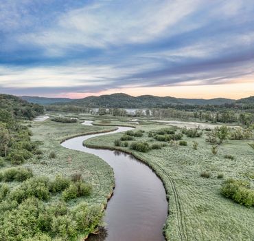 A scenic view of a meandering river through lush greenery in Tell, Wisconsin.