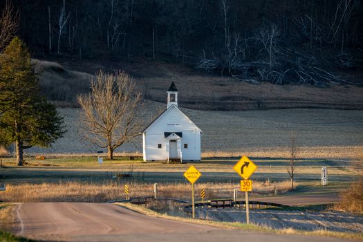 A picturesque rural chapel near a country road in Wisconsin, USA, during a peaceful day.