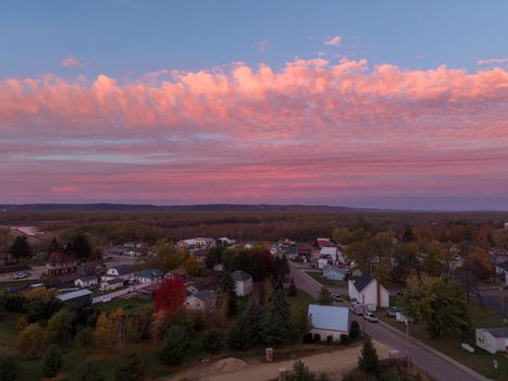 A stunning aerial view of Nelson, Wisconsin during a vibrant sunset with pink clouds overhead.