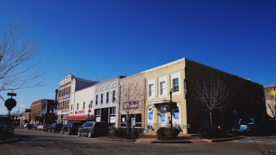 cars parked in front of white concrete building during daytime