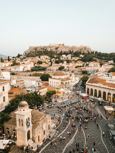 A crowd of people in Monastiraki Square with the Acropolis in Athens, Greece