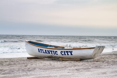 White boat with "atlantic city" text on beach