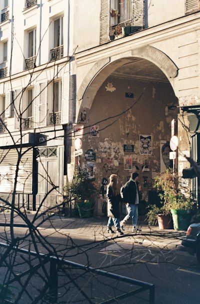 a couple of people that are walking in front of a building