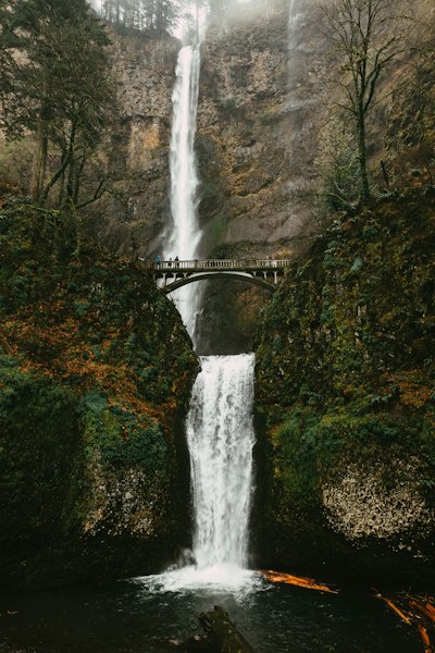 a large waterfall with a bridge over it