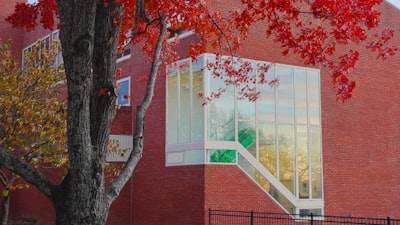 a red brick building with a tree in front of it