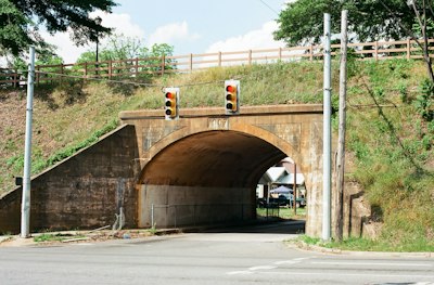 Arched concrete bridge over a road with traffic lights