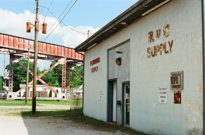 White rvs supply building next to a rusty industrial gantry