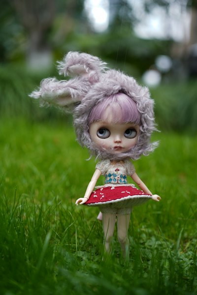A small doll with a pink hair and a red dress