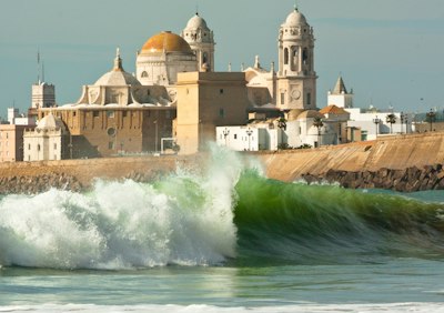 a large wave is breaking in front of a building
