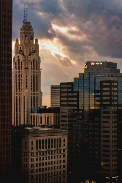 A city skyline with tall buildings and a cloudy sky