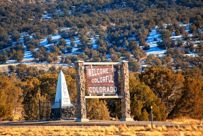a welcome sign in front of a mountain