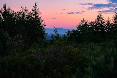 the sun is setting over the mountains in the distance