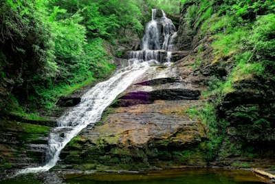 waterfalls on brown rocky mountain during daytime