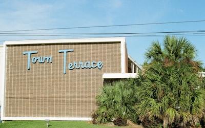 A building with a "town terrace" sign and palm trees