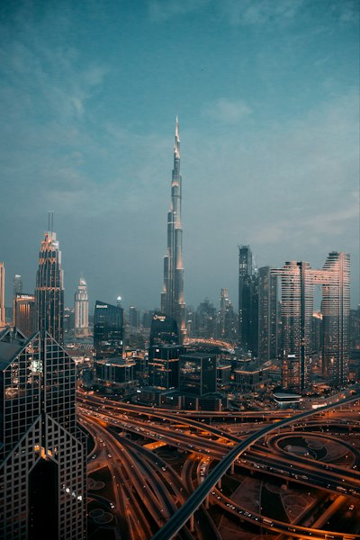 The Burj Khalifa tower rising above the illuminated skyline and highway interchange in Dubai