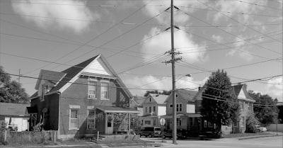 a black and white photo of houses and power lines