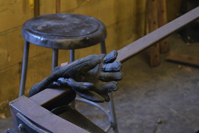 a pair of gloves sitting on top of a metal bench