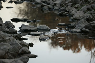 gray rocks on body of water during daytime