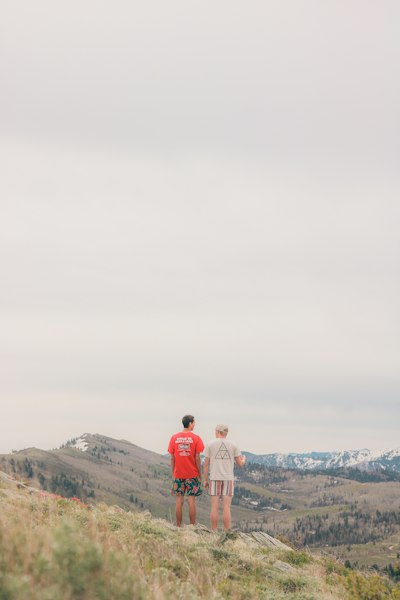 Two men stand and gaze at mountain scenery