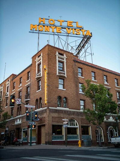A tall brick building with a neon sign above it