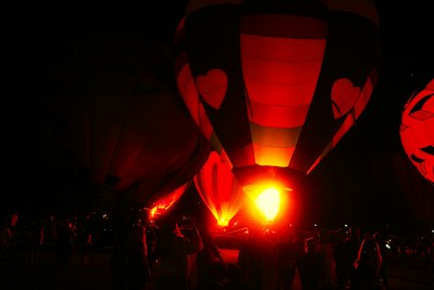 Hot air balloons glow with fire at night