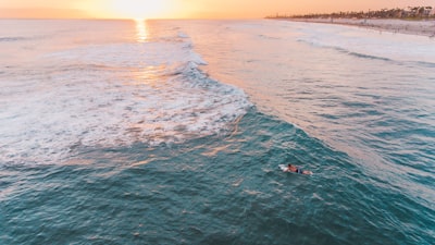 person riding on knee board on body of water