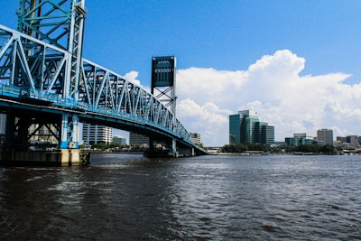 A bridge over a body of water with a city in the background