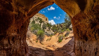 a view of a canyon through a hole in a rock