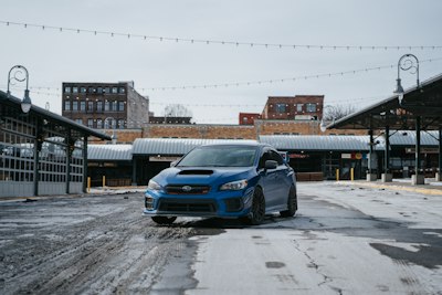 a blue subarunt parked in front of a building