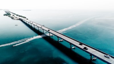 A bridge spans across the calm, blue ocean