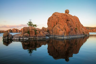 a large rock sitting in the middle of a lake