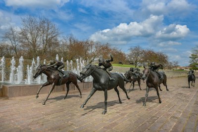 Bronze statues of jockeys riding horses in a race