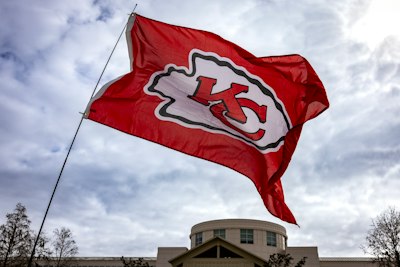 a kansas chiefs flag flying in front of a building