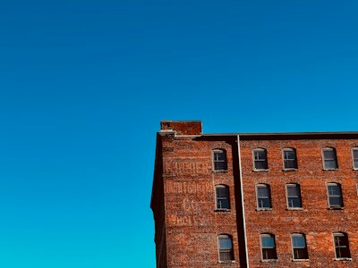 a tall brick building with a clock tower in the background