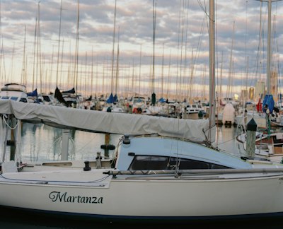 white and blue sail boat on dock during daytime
