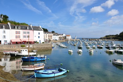 boats on sea near houses during daytime