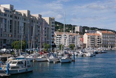 a harbor filled with lots of boats next to tall buildings