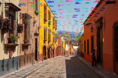 a cobblestone street lined with colorful flags