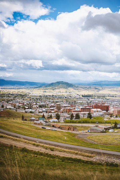 a scenic view of a city with mountains in the background