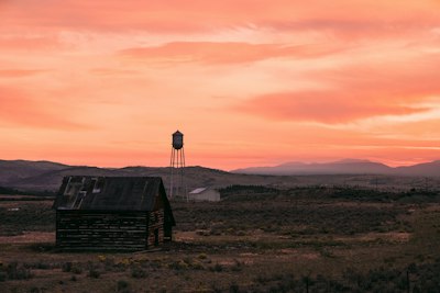 a barn and a water tower at sunset
