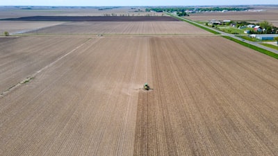 an aerial view of a farm with a tractor in the middle of the field