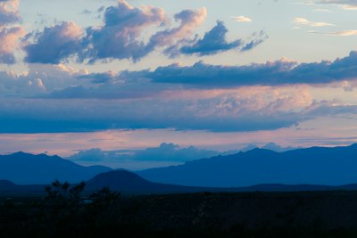 a view of a mountain range with clouds in the sky