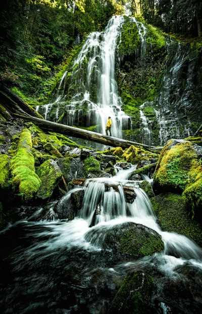 a man standing in front of a waterfall