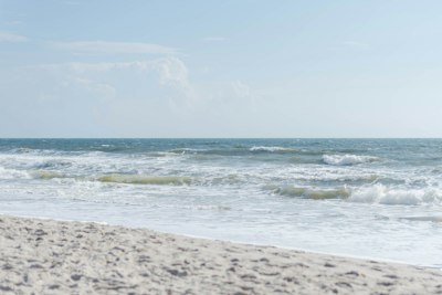 a person walking on the beach with a surfboard