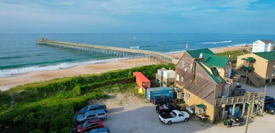 an aerial view of a beach with cars parked in front of it