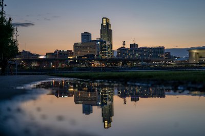 a city skyline is reflected in a body of water