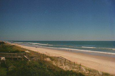 a view of a beach and ocean from the top of a hill