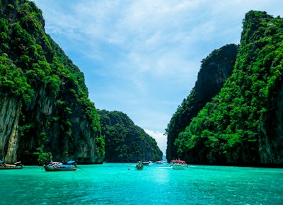 boats on sea near mountain during daytime